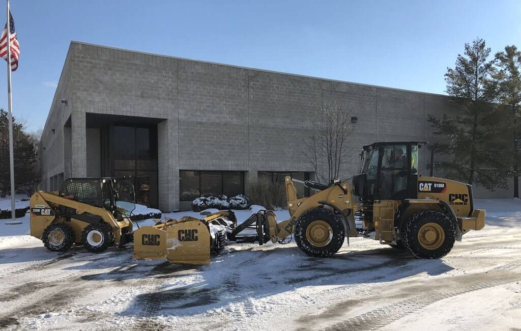 CHC Total wheel loaders with snow pushers clearing a commercial parking lot in Southeast Michigan