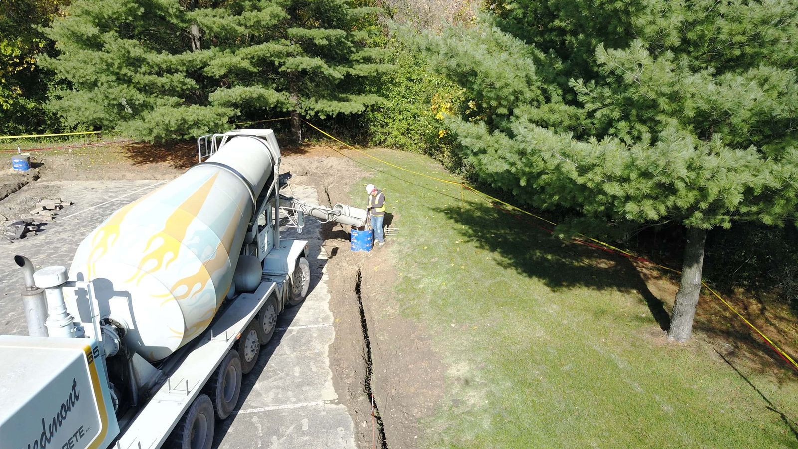 Aerial view of a ready-mix concrete truck pouring a curb and footing