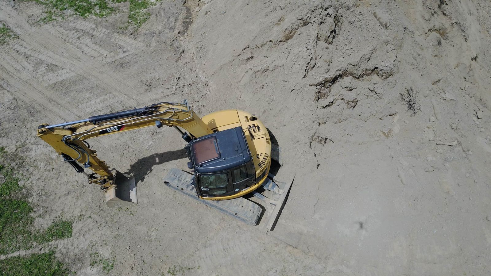 Aerial view of an excavator mass grading sand on a site-preparation job