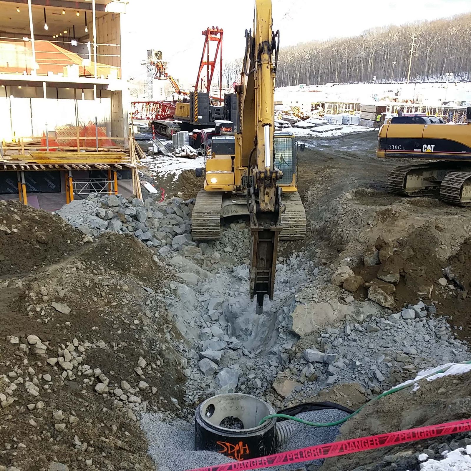 Excavator with a hydraulic breaker demolishing concrete in an urban excavation