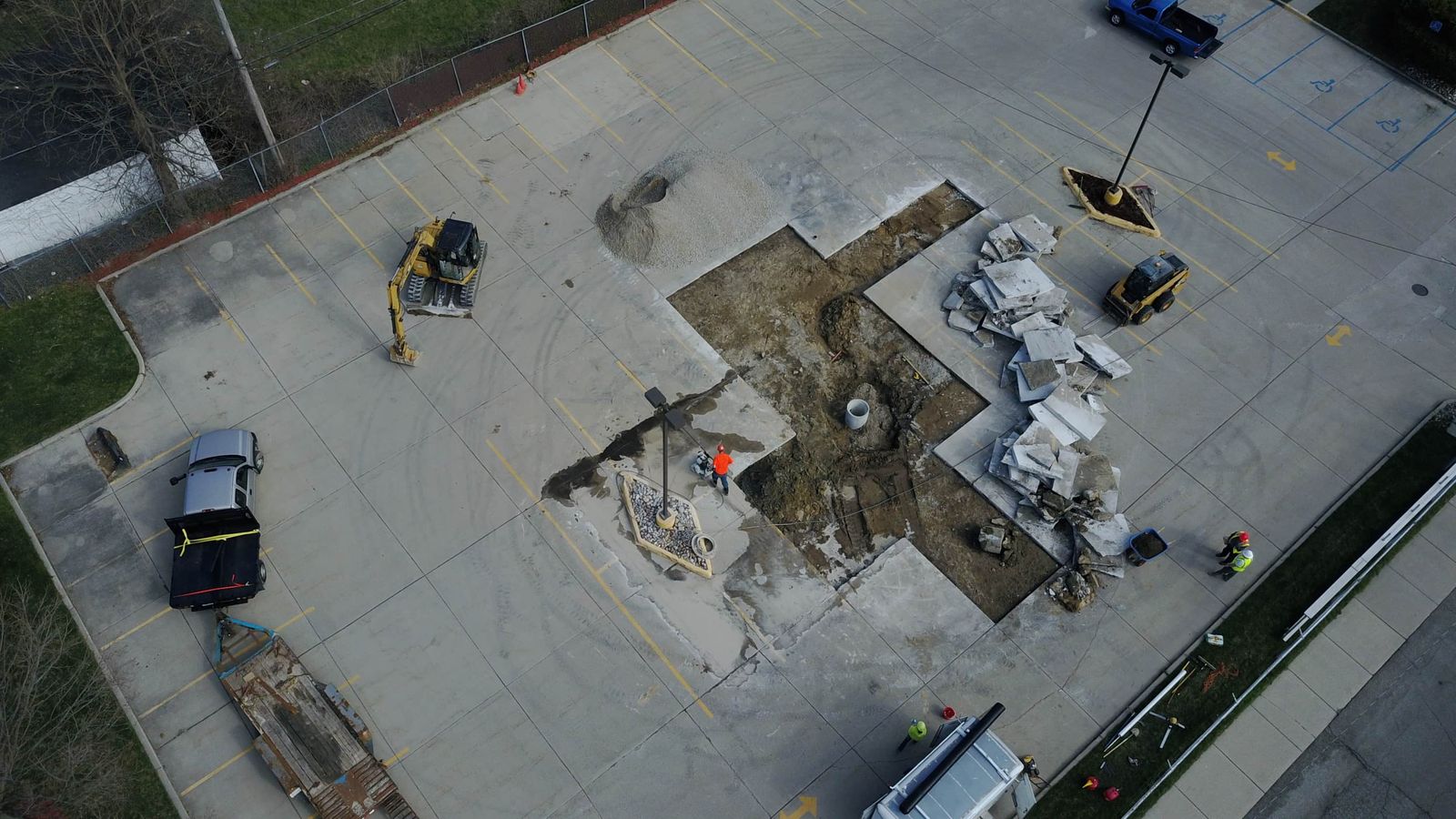 Aerial view of underground utility excavation and concrete removal at a commercial property